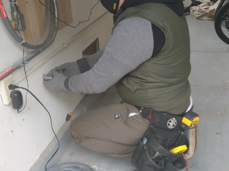 Electrician performing outlet wiring in a Desert Aire garage